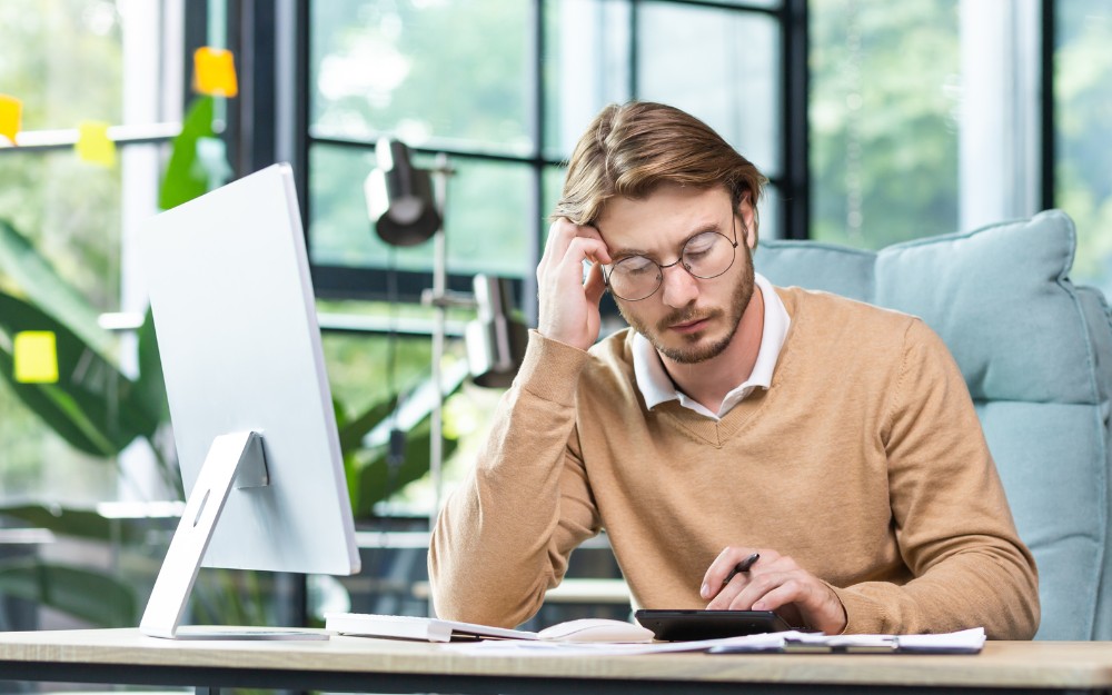 Pensive man, struggling with debt and considering debt consolidation