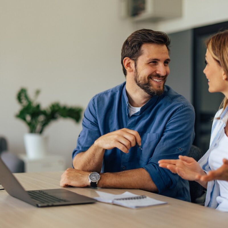Couple talking about home loans while researching interest rate cuts